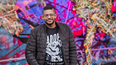 Rey Rosa in front of mural