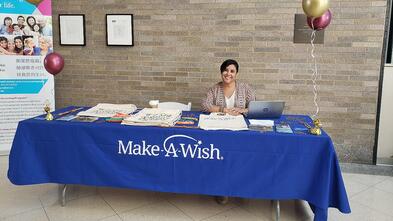 Angela working Make-A-Wish table at event