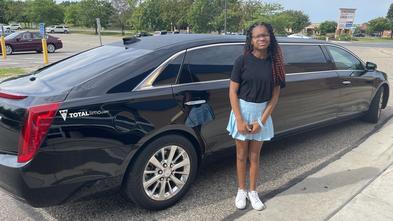 Carrington in front of a limo on her wish day. 