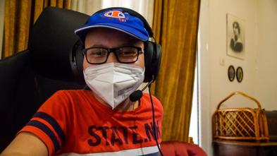 Vassilis, age 10, in blue ball cap and face mask, wearing gaming headset.
