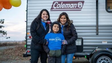 Wish child Sebastian smiling with Make-A-Wish volunteers