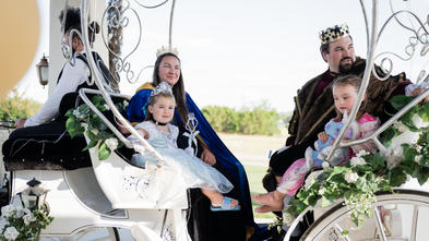 Addie and her family riding in a horse drawn carriage.