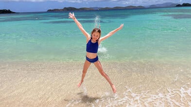 wish kid Claire jumping in the air on the beach