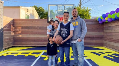 Wish Kid Isaiah with his family on his new backyard basketball court