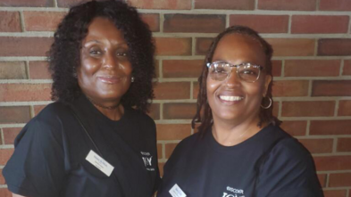 Two smiling volunteers