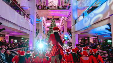 Holiday dancers in front of lit tree