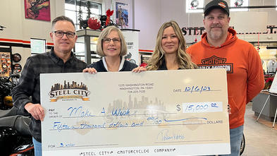 associates of Steel City Harley-Davidson with General Manager, Pokey Weiss and Marketing Director and Event Coordinator Lisa Bakaysza-Cepaiti presenting Director of Development Stephanie Pugliese with a check totaling $15,000.