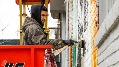 Man painting mural on wall