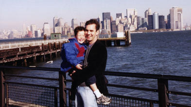 Matthew being held by his uncle Lucas with the New York city skyline in the background