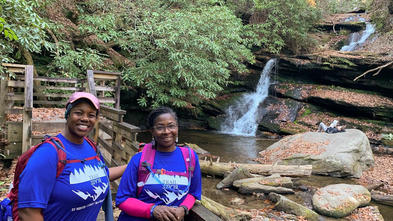 Trailblaze participants enjoying the scenery in front of a waterfall.
