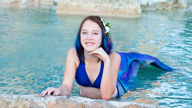 Emily poses in the water with her custom mermaid tail.