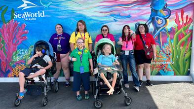 Wish kid Poseidon and his family each wearing a different color representing a rainbow