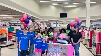 wish kid and her family smiling with craft store employees