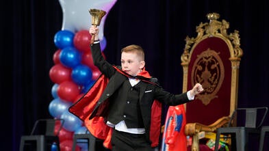 Wish kid ringing a bell running across the stage