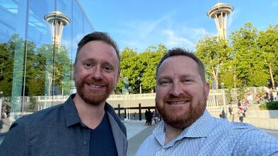 Caleb and Derek standing outside with the Space Needle in the background