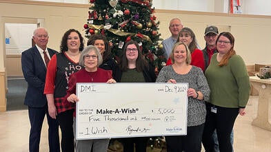 Pictured here are DMI employees presenting a donation to Stephanie Pugliese, Make-A-Wish director of development.