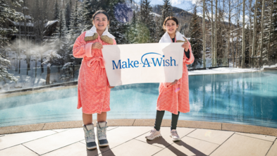 photo of Antonia and sister holding Make-A-Wish banner