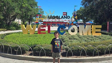 Wish kid standing outside main entrance to Legoland
