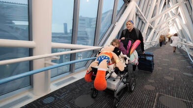 Mom and wish child entering hospital across pedestrian bridge