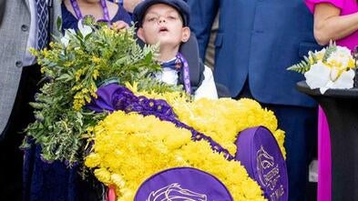 Wish kid Cody Dorman sits draped with honors at the Breeder's Cup Dirt Mile race.