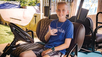 Kainoa sitting in his new customized golf cart