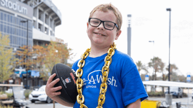 Blaze holding a football in front of Jaguar's stadium