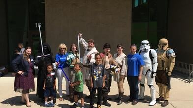 Dave posing with star wars characters and wish kids