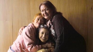 Guadalupe shares a hug with her mother and grandmother.