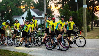 Group of bicycle riders waving at the camera