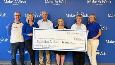 group holding large checks