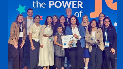 A group of people pose while holding an award. 