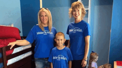 Beth standing next to another volunteer and wish kid