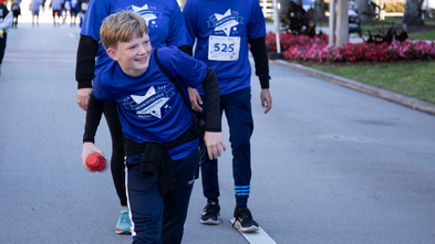 Kid smiling as he walks across the finish line at WFW