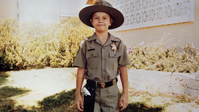 Wish kid Chris in a police uniform