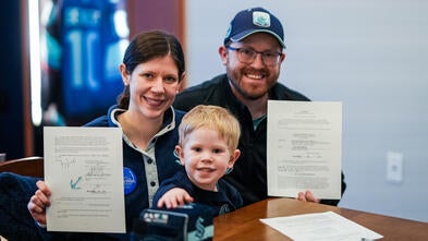 Wish kid Caleb and his parents holding the Kraken Contract