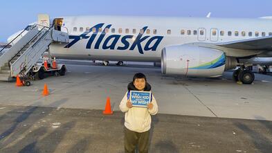 Wish kid in front of Alaska Airplane