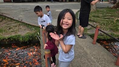 Avery feeding koi fish at a koi fish pond