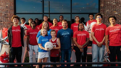 Waiters for Wishes event photo with a group of people wearing red shirts 