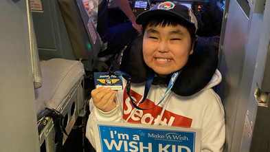 Wish Kid Owen smiling in an airplane