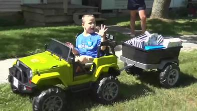 Bentley waves as he drives his new Power Wheels Jeep.