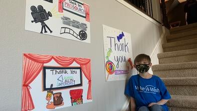 Miles smiling with thank you posters