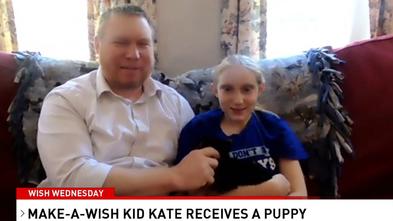 Kate sits on the couch holding her new puppy as she and her dad discuss Kate's recent wish