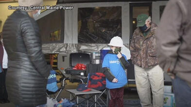 Caleb stands in front of his new camper, surrounded by his family