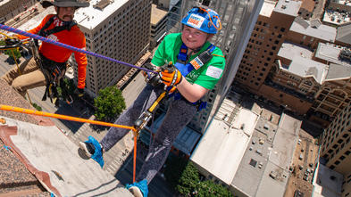 Wish kid Ana Kate rappelling off of 600 Congress.