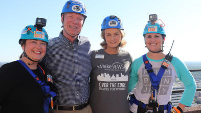 IBC Bank CEO, Make-A-Wish Central & South Texas CEO, and IBC employees stand with helmets on top of 600 Congress