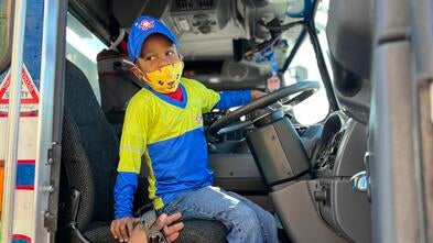 Jelani rides shotgun in a Republic Services garbage truck.