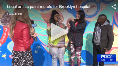 Mural artists in front of new community mural at Brookdale Hospital