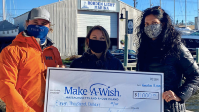 The owners of Borden Light Marina hold a check for $11,000.