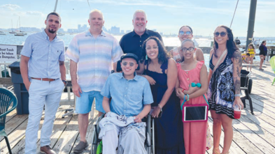 A wish child and family pose with Make-A-Wish CEO Sean Holleran and Cottage Park Yacht Club Commodore John Cataldo