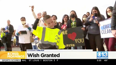 Wish Kid Carter waves as he is cheered on by a crowd